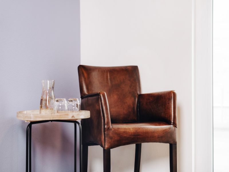 Ledersessel und Beistelltisch mit Wasserkaraffe und Gläsern in einem modernen Wartebereich